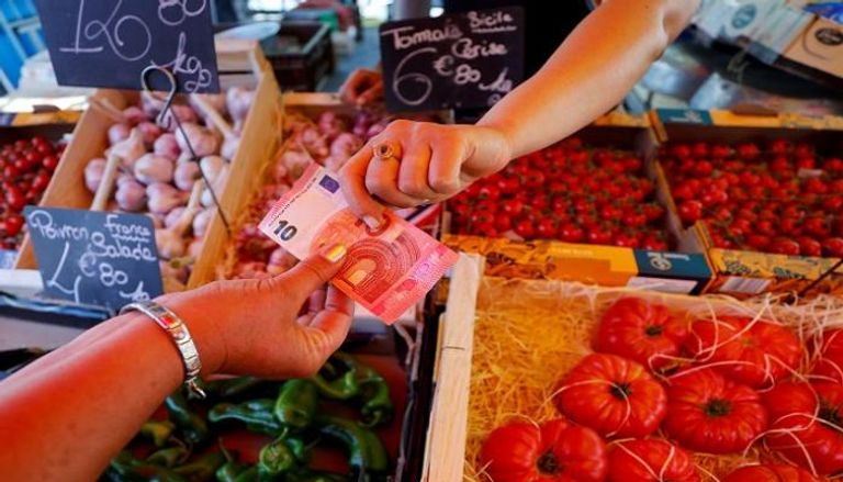 متسوق يدفع 10 يورو في سوق محلي بنيس الفرنسية - رويترز