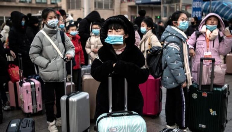 مسافرون يرتدون كمامات للوقاية من فيروس كورونا
