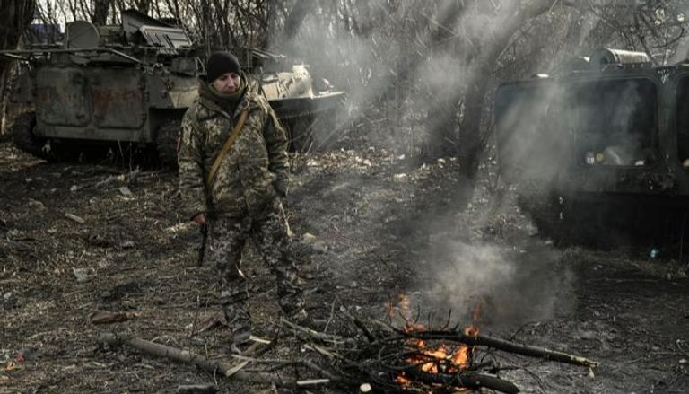 جندي أوكراني يقف بجانب حريق في منطقة دونباس 