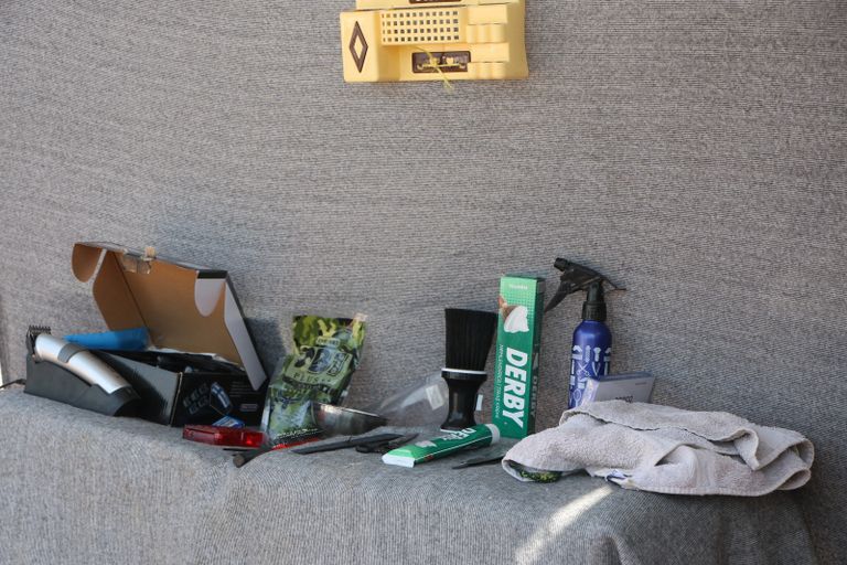 أحمد يرتب أدوات صالونه المتواضع في المخيم