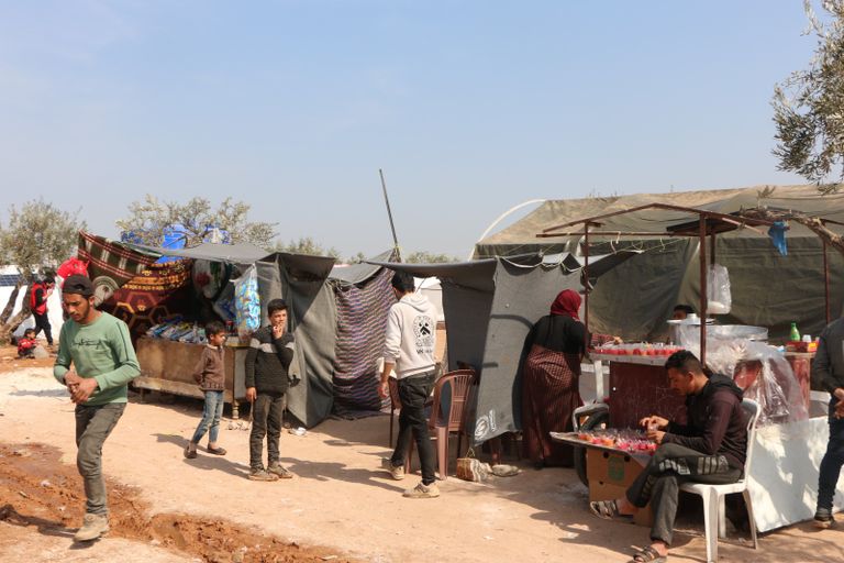 أحمد يرتب أدوات صالونه المتواضع في المخيم