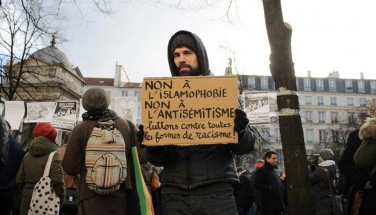 محتج فرنسي يحمل لافتة تندد بالإسلاموفوبيا- أرشيفية