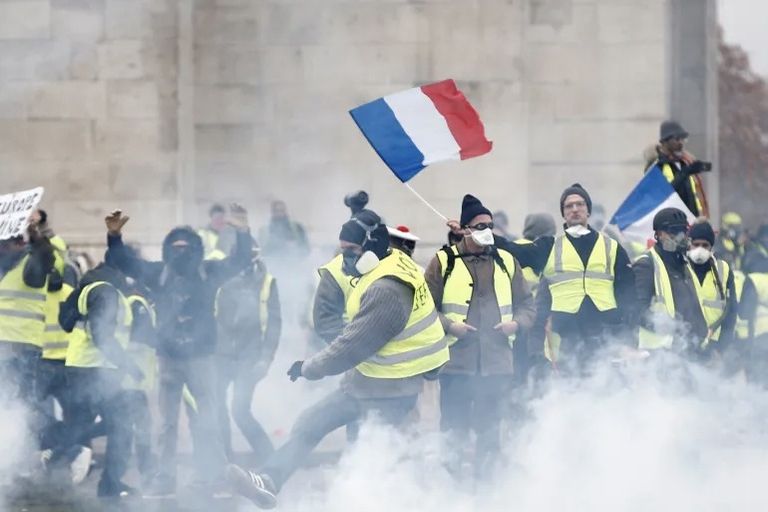 محتجون يرفعون مجسما ورقيا لماكرون في باريس