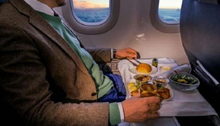 مسافر يأكل في الطائرة- أرشيفية
