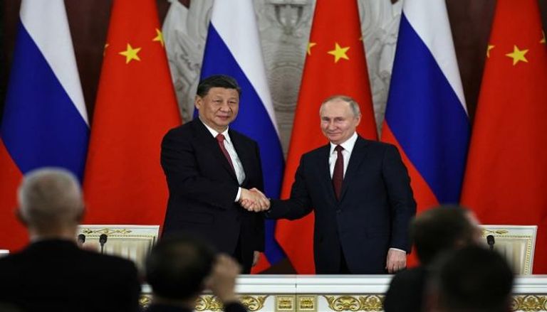 الرئيس الصيني شي جين بينغ يصافح نظيره الروسي بوتين في موسكو