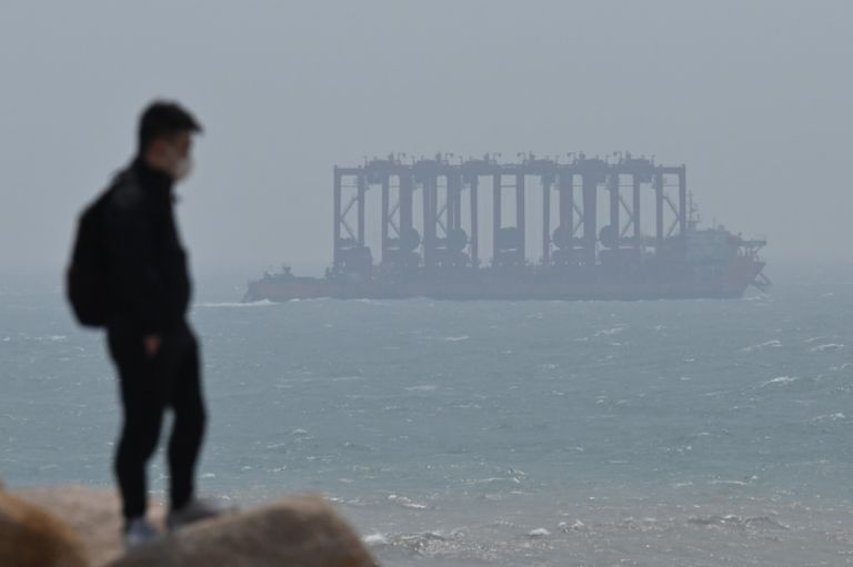 رجل يلتقط صورة لامرأة تحت إطار أمام مضيق تايوان