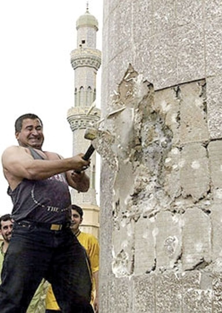 جنود أمريكيون وعراقيون يصعدون لتمثال صدام