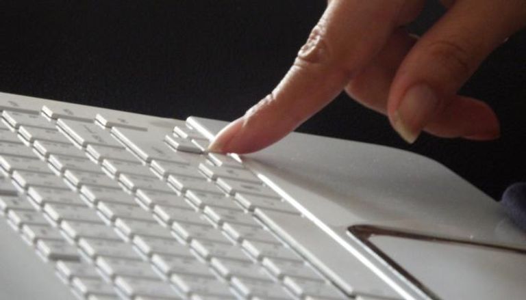 امرأة تضغط زرا على لوحة المفاتيح