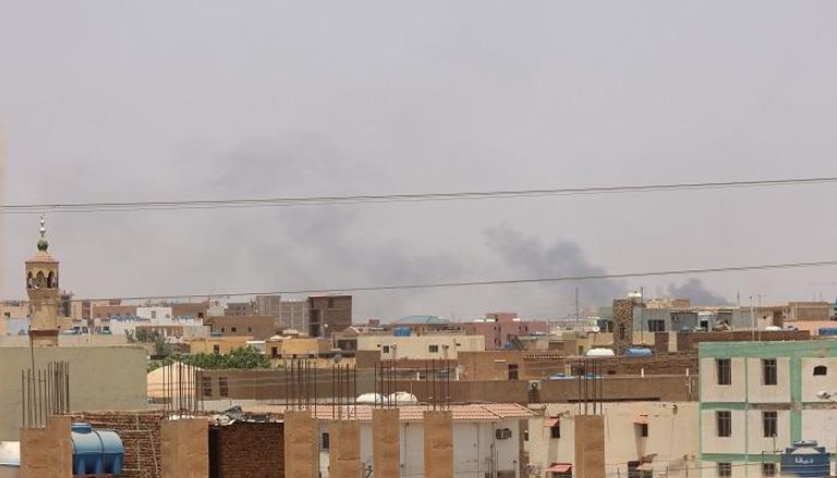 دخان يتصاعد خلف مسجد ومباني سكنية بشرق الخرطوم