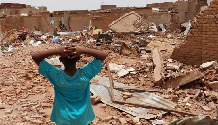 طفل سوداني يقف على أطلال منزله