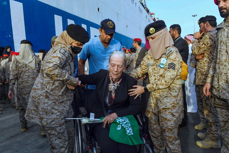 مجندة بالقوات البحرية الملكية السعودية تحمل طفلا قادما من السودان