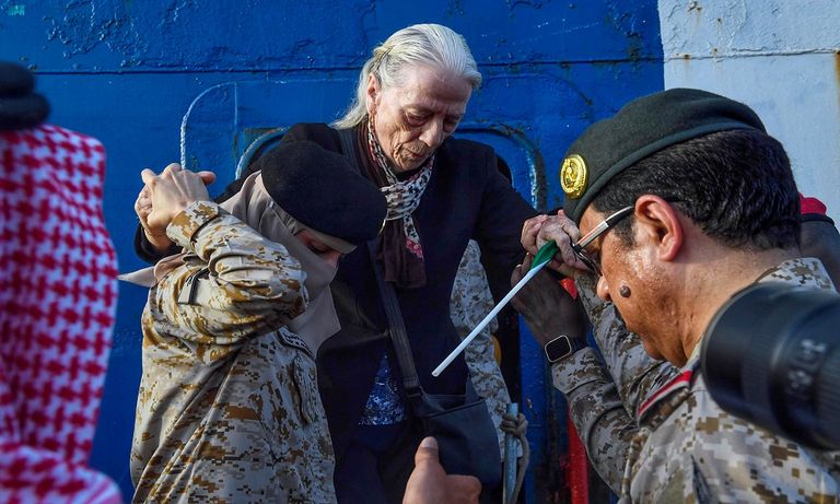 مجندة بالقوات البحرية الملكية السعودية تحمل طفلا قادما من السودان