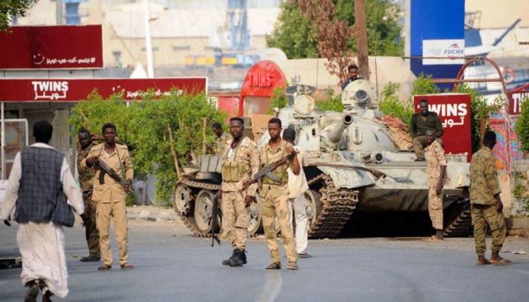 جنود من الجيش السوداني يجلسون فوق دبابة 