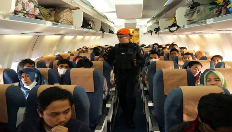 بريطانيون يسيرون باتجاه طائرة تابعة لسلاح الجو البريطاني أثناء الإجلاء إلى قبرص