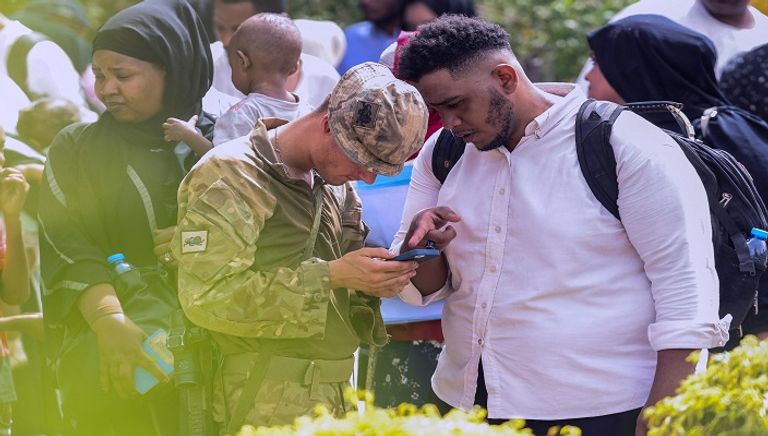 بريطانيون يسيرون باتجاه طائرة تابعة لسلاح الجو البريطاني أثناء الإجلاء إلى قبرص