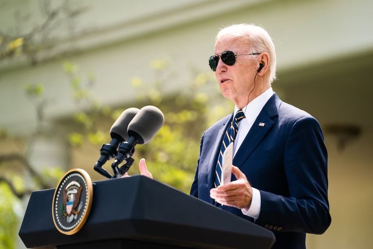 الرئيس الأمريكي جو بايدن يحمل بطاقة بها اسم الصحفية