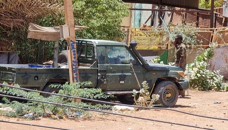 عناصر من قوات الأمن التابعة للجيش السوداني يقفون بجوار سيارتهم بالخرطوم