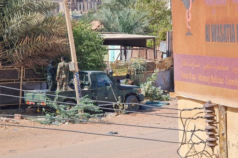 جنود في أحد شوارع السودان سيدة سودانية تمر قرب محال تجارية مغلقة بالخرطوم