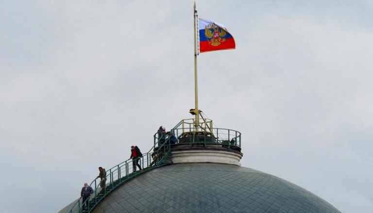 روس على قبة قصر مجلس الشيوخ التي يعلوها العلم (أحد مباني الكرملين الرئيسية) 