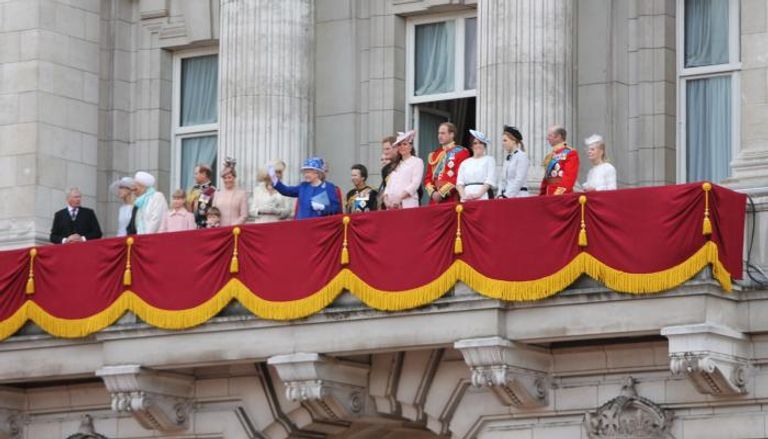عدد من أفراد العائلة الملكية يقفون في شرفة القصر مع الملكة الراحلة