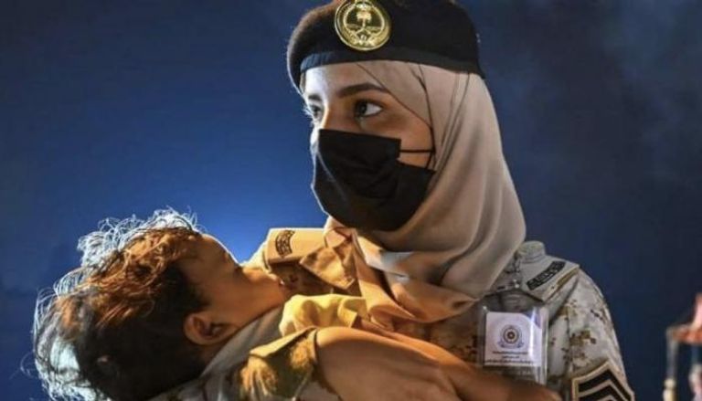 المجندة السعودية وهي تحتضن طفلة قادمة من السودان