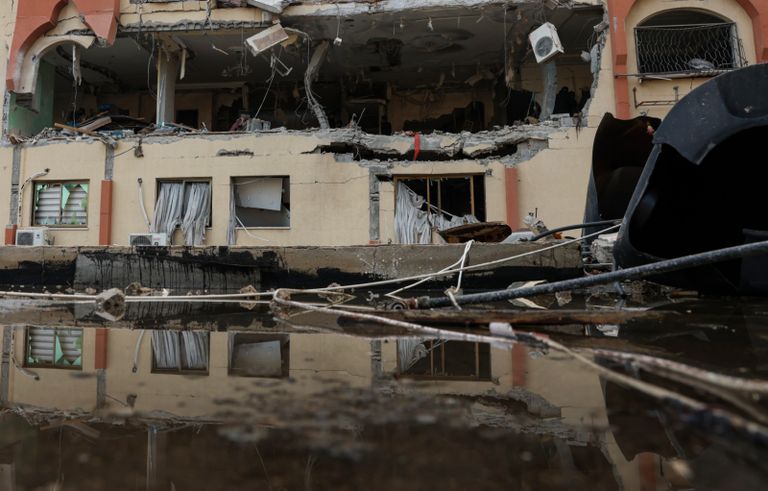 فلسطينية تشاهد من نافذتها جنازة ضحايا العملية الإسرائيلية