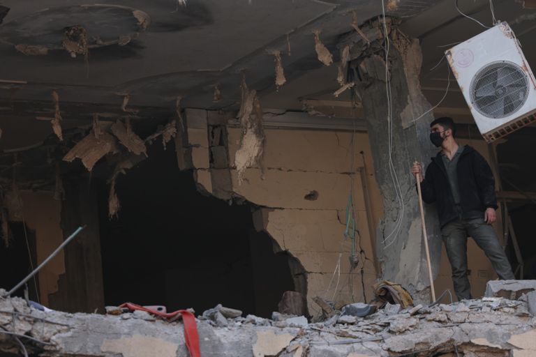 فلسطينية تشاهد من نافذتها جنازة ضحايا العملية الإسرائيلية