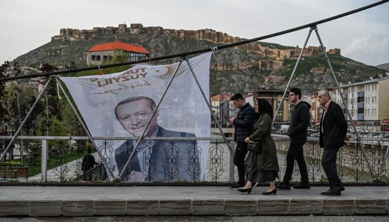 مارة قرب لافتة لرجب طيب أردوغان في بايبورت