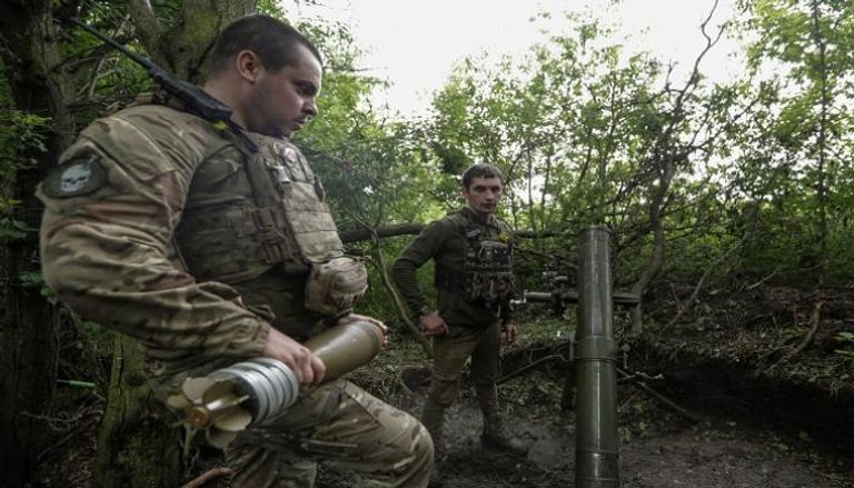 جنود أوكرانيون يستعدون لإطلاق قذيفة مورتر باتجاه القوات الروسية في منطقة دونيتسك