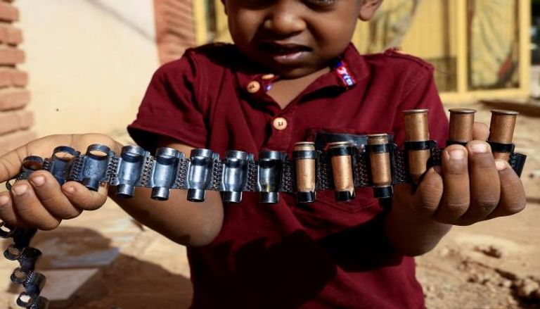 طفل سوداني يحمل خراطيش الرصاص -رويترز
