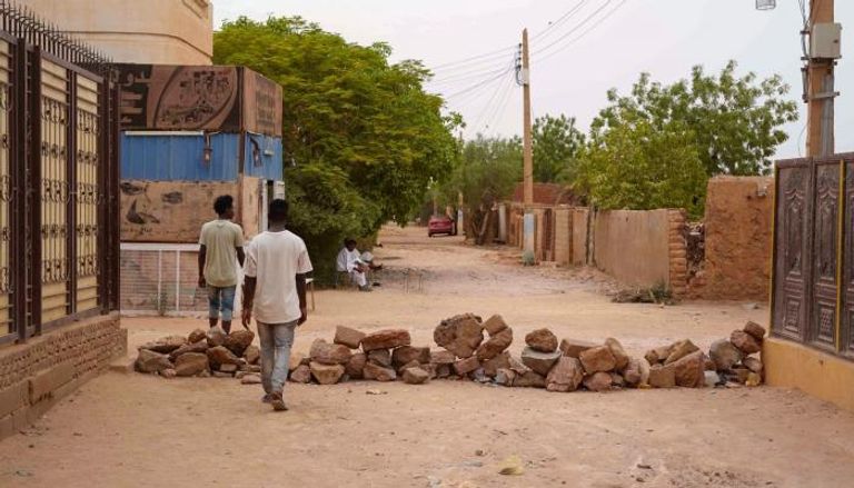 سودانيون أمام حاجز من الطوب في أم درمان