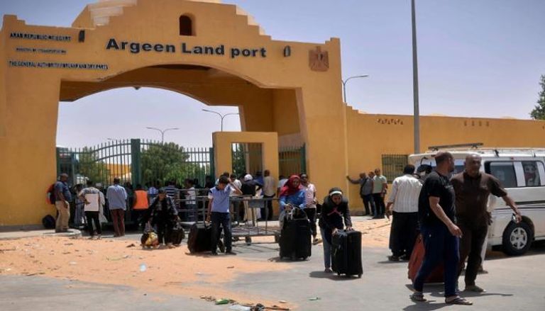 سودانيون يعبرون منفذا حدوديا بين مصر والسودان
