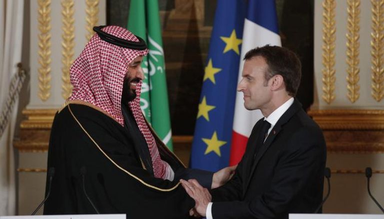 ولي العهد السعودي يصافح الرئيس الفرنسي خلال لقاء سابق - أرشيفية