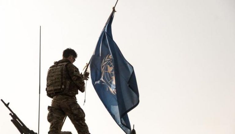 جندي يرفع علم الأمم المتحدة فوق آلية عسكرية تابعة لقوات حفظ السلام - أرشيفية