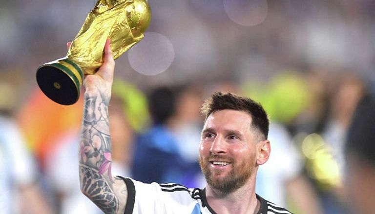 ميسي بقميص منتخب الأرجنتين ومعه كأس العالم الأسطورة ليونيل ميسي
