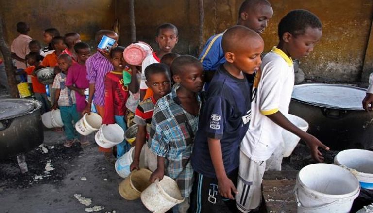 أطفال أفارقة ينتظرون دورهم للحصول على الطعام والماء - أرشيفية