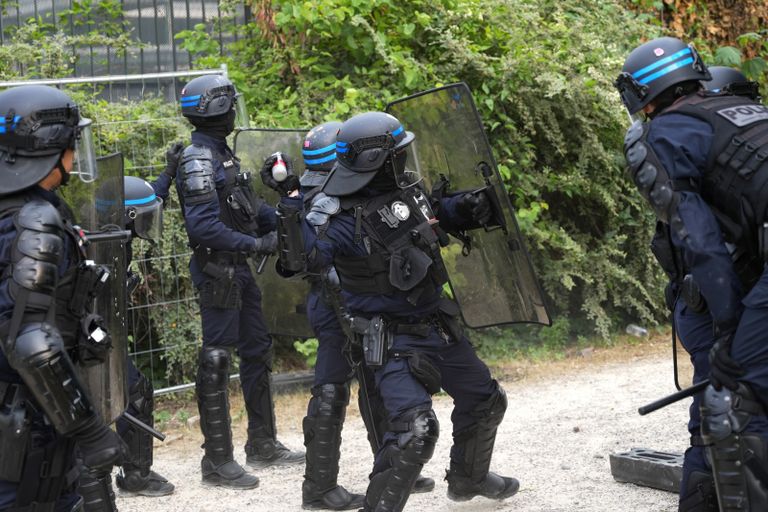 شرطي فرنسي قرب جدار كتب عليه المحتجون اسم نائل