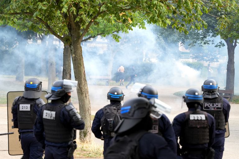 شرطي فرنسي قرب جدار كتب عليه المحتجون اسم نائل