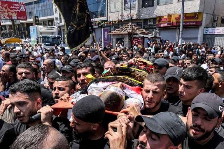 امرأة أمام ركام مبانٍ في جنين