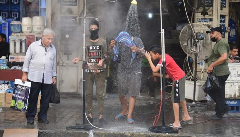 عراقيون يرشون أجسادهم بالمياه لمواجهة الحر الشديد