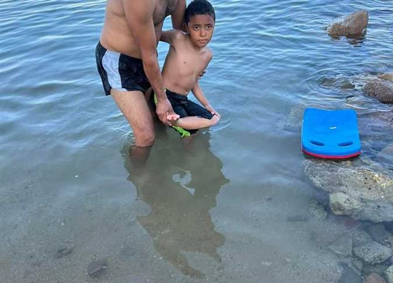 مصري يلقي زجاجا مكسورا في شواطئ الغردقة