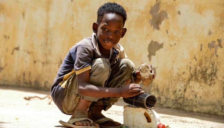 طفل سوداني يلهو بلعبته في بلد مشغول بالصراع- الفرنسية