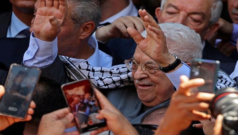 الرئيس الفلسطيني متشحا بالكوفية وممسكا بغصن الزيتون خلال زيارة جنين