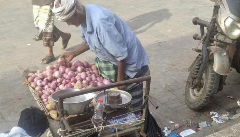 مسن يمني يبيع البصل الأحمر في أحد الشوارع.. أرشيفية