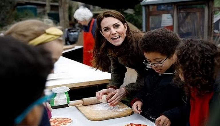 كيت، أميرة ويلز، أثناء إعداد البيتزا في زيارة لأحد المدارس