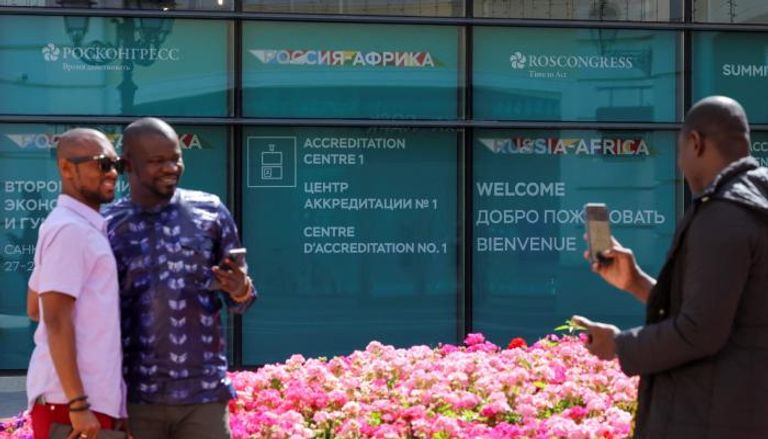 رجال يلتقطون صورا أمام مقر انعقاد القمة الروسية الأفريقية