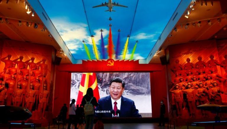 زوار أمام صورة الرئيس الصيني في المتحف العسكري - رويترز 