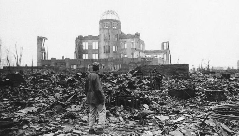 رجل يقف وسط هيروشيما بعد تدميرها بالقنبلة النووية