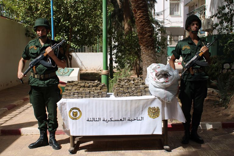 جنديان جزائريان بجانب بعض المضبوطات جنود جزائريون مع الأسلحة والذخيرة المضبوطة