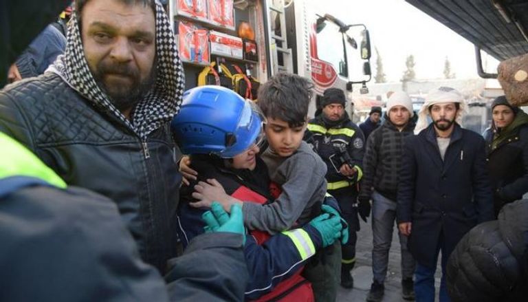 عضو فريق الإنقاذ الإماراتي تحمل طفلاً بعد انتشاله من تحت أنقاض الزلزال